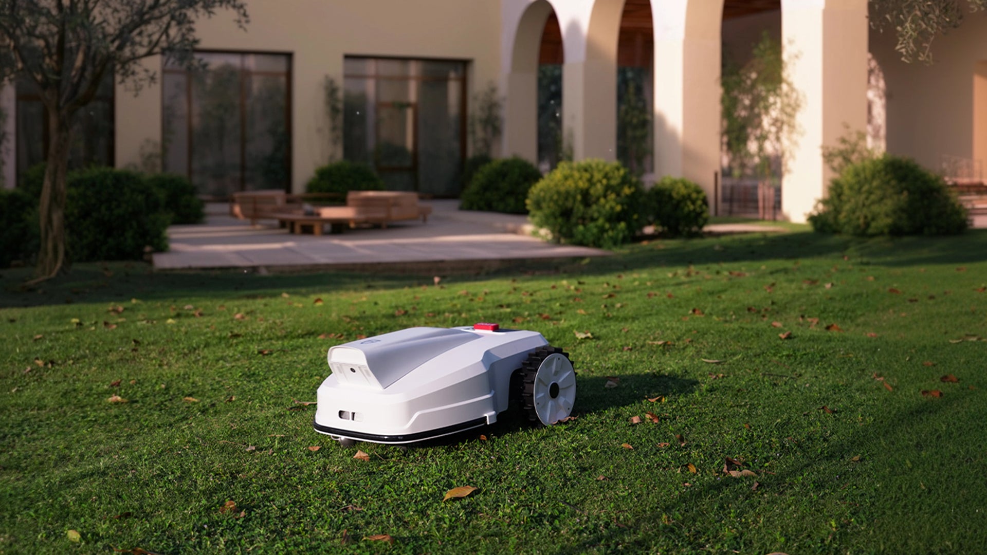 Robotic lawn mower on a grassy lawn in front of a house